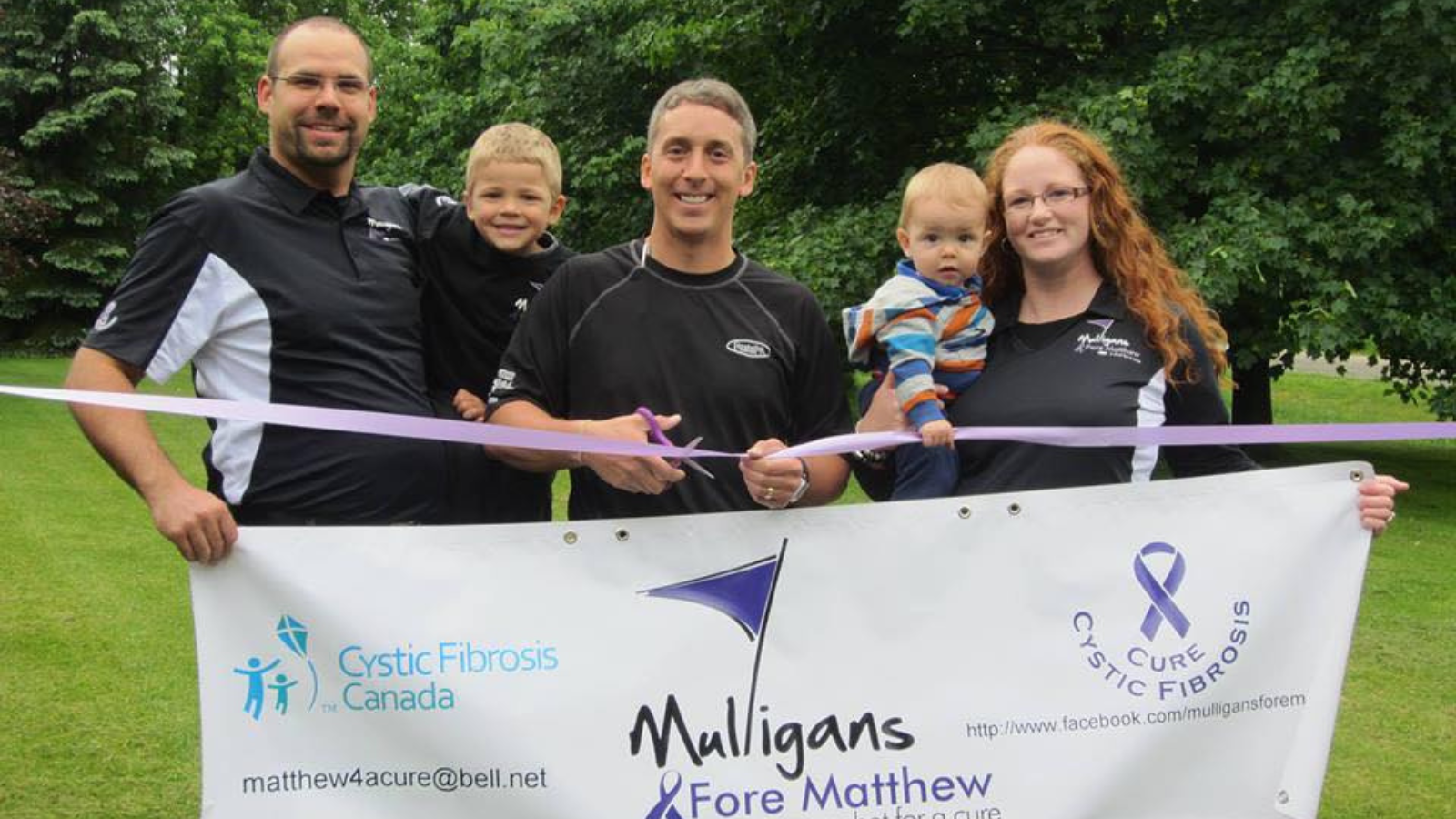 Gillian and her family holding a sign up at a golf course for their event, Mulligans Fore Matthew